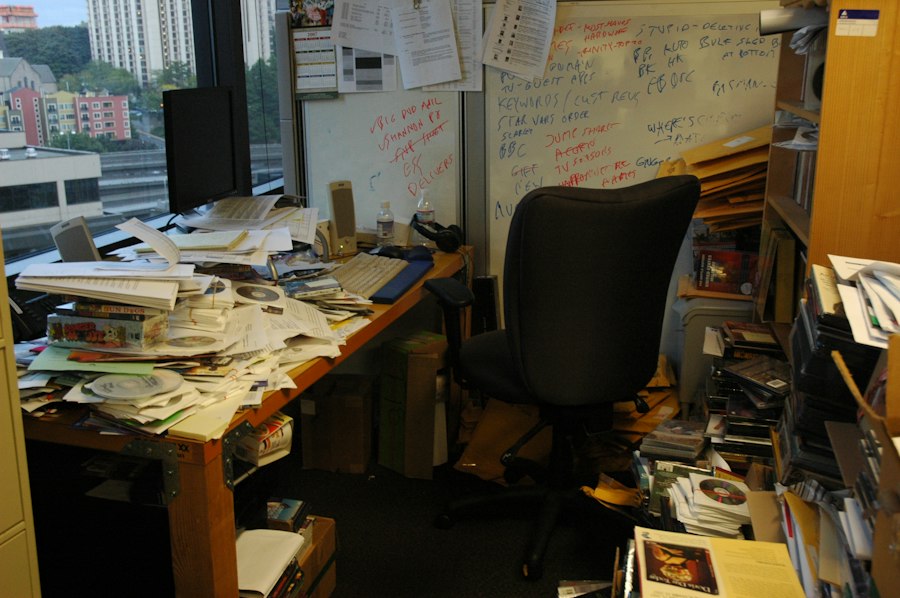 An office desk buried under piles of paper